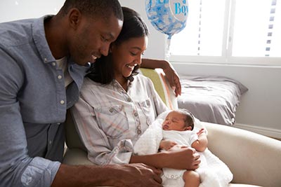 adoptive parents looking down at newborn