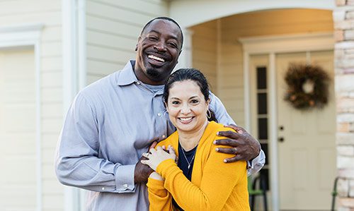 Happy interracial couple outside their home