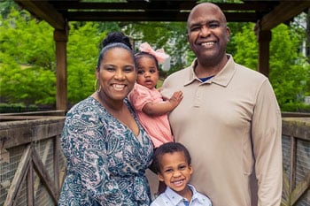 happy Lifetime Adoption family standing on a bridge